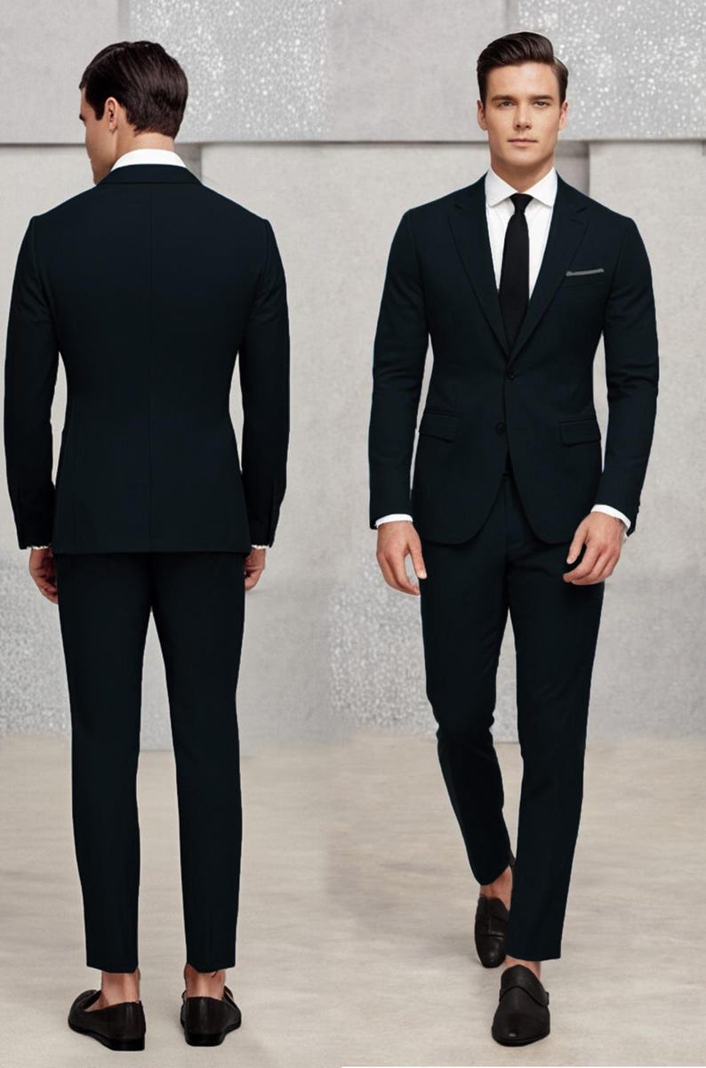 May include: A black suit with a single-breasted jacket and matching trousers. The jacket has a notch lapel and a pocket on the left side. The man is wearing a white shirt and a black tie.