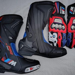 May include: A pair of black, red, and blue motorcycle boots with S 1000 RR branding and a pair of matching black, red, and white motorcycle gloves with BMW M 1000 RR text and logos, featuring protective metal knuckle guards and reinforced panels.