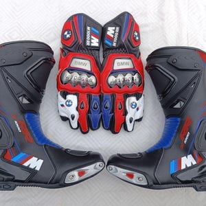 May include: A pair of black, red, and blue motorcycle boots and a pair of matching motorcycle gloves. The boots feature the M1000 RR logo and BMW branding. The gloves have metallic knuckle protectors, BMW logos, and M1000 RR text on the cuffs.
