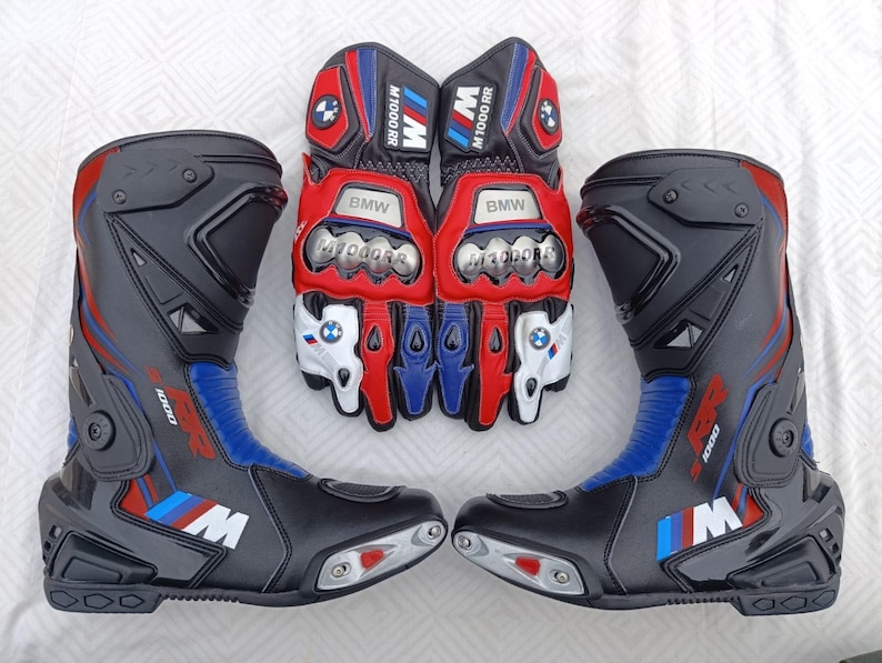 May include: A pair of black, red, and blue motorcycle boots and a pair of matching motorcycle gloves. The boots feature the M1000 RR logo and BMW branding. The gloves have metallic knuckle protectors, BMW logos, and M1000 RR text on the cuffs.