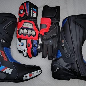 May include: A pair of black, blue, and red motorcycle boots with S 1000 RR branding and a pair of matching black, red, and white motorcycle gloves featuring BMW M 1000 RR logos, metallic knuckle protectors, and adjustable wrist straps.