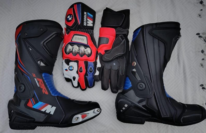 May include: A pair of black, blue, and red motorcycle boots with S 1000 RR branding and a pair of matching black, red, and white motorcycle gloves featuring BMW M 1000 RR logos, metallic knuckle protectors, and adjustable wrist straps.