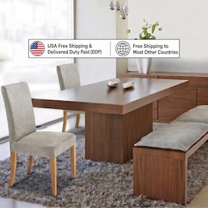 May include: A dining set featuring a rectangular wooden table with a central pedestal base, two light gray upholstered chairs, and a matching wooden bench with a long light gray cushion. The text USA Free Shipping & Delivered Duty Paid (DDP) and Free Shipping to Most Other Countries is visible.