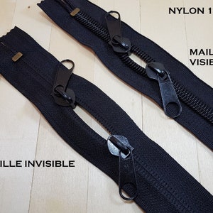 Peut inclure: Deux fermetures éclair en nylon noir, l'une avec des dents visibles et l'autre avec des dents invisibles. Les deux fermetures éclair ont des curseurs et des tirettes en métal noir. Le texte "NYLON 10" et "MAILLE VISIBLE" est visible sur la fermeture éclair du haut. Le texte "MAILLE INVISIBLE" est visible sur la fermeture éclair du bas.