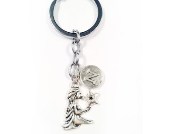 May include: Silver keychain featuring a Virgo zodiac sign charm with a star and a charm with the letter 'Z'.