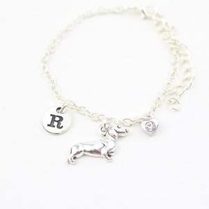 Op de afbeelding: Zilveren armband met een teckelbedel, een hartbedel en een bedel met de letter R.