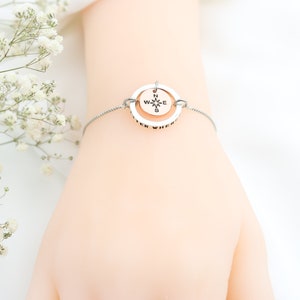 May include: A silver bracelet with a compass charm that reads "Wherever you go, go with all your heart".