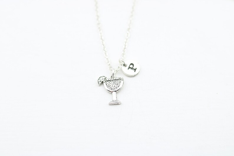 May include: Silver necklace with a charm of a margarita glass and a letter 'P' charm.