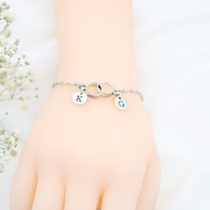 Dos pulseras iniciales con dos anillos