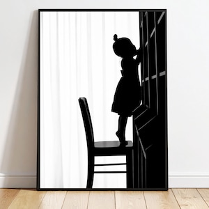 May include: Black and white framed art print featuring a silhouette of a child standing on a chair, reaching towards a geometric structure. The artwork evokes a sense of curiosity and exploration, set against a white backdrop.