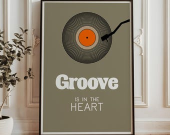 May include: A framed poster with a black border features a vinyl record illustration with an orange center. The words "Groove is in the Heart" are displayed in white text against a muted green background. The phrase "Frame not included" is at the bottom.
