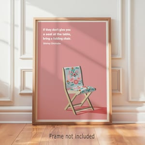 Puede incluir: Una impresión enmarcada con un fondo rosa y una silla plegable con un diseño floral. El texto dice: "Si no te dan un asiento en la mesa, trae una silla plegable. Shirley Chisholm." El marco es de madera. "Marco no incluido" está en la parte inferior.