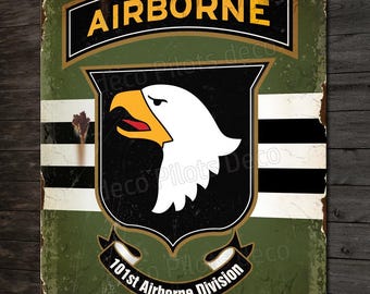 May include: A vintage-style metal sign with a green background and a black and white eagle emblem. The sign reads "AIRBORNE" in yellow letters and "101st Airborne Division" in white letters. The sign also includes the text "D-DAY 6.6.1944" in white letters.