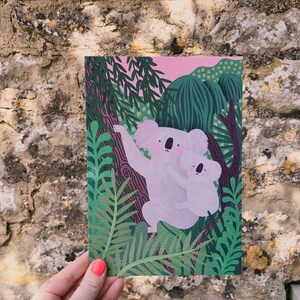 May include: A digital illustration of two koalas, a mother and baby, sitting in a lush green forest. The koalas are light pink and have black eyes and noses. The forest is filled with green leaves and branches.