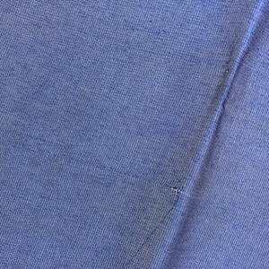 May include: Close-up of a blue fabric with a textured weave. The fabric is folded in half, creating a seam down the center.