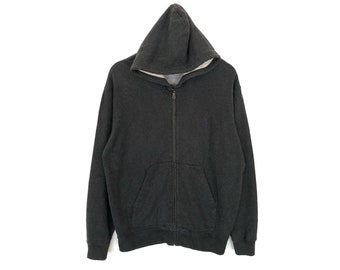 May include: A dark gray hooded sweatshirt with a zipper closure. The sweatshirt has a kangaroo pocket and a small logo on the chest.