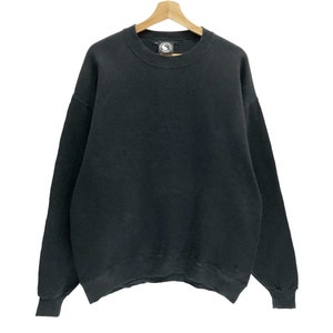 Puede incluir: Una sudadera negra de manga larga con cuello redondo.