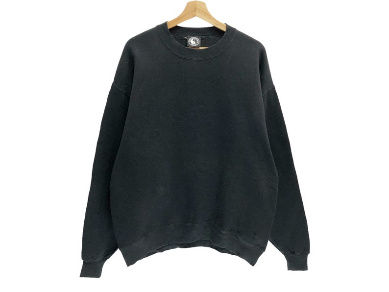 Puede incluir: Una sudadera negra de manga larga con cuello redondo.