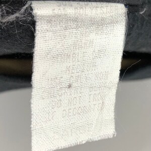 Puede incluir: Etiqueta de cuidado de la tela blanca con texto negro que dice "Lavar a m&aacute;quina con agua fr&iacute;a", "Secar en secadora a baja temperatura", "No usar blanqueador", "No planchar", "No limpiar en seco".