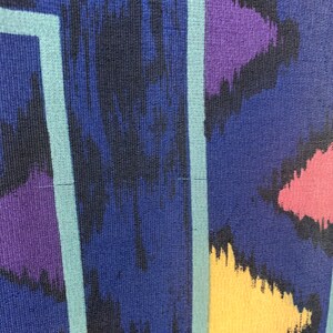 May include: Abstract pattern fabric with a blue background and colorful geometric shapes. The fabric has a textured surface and a striped pattern.
