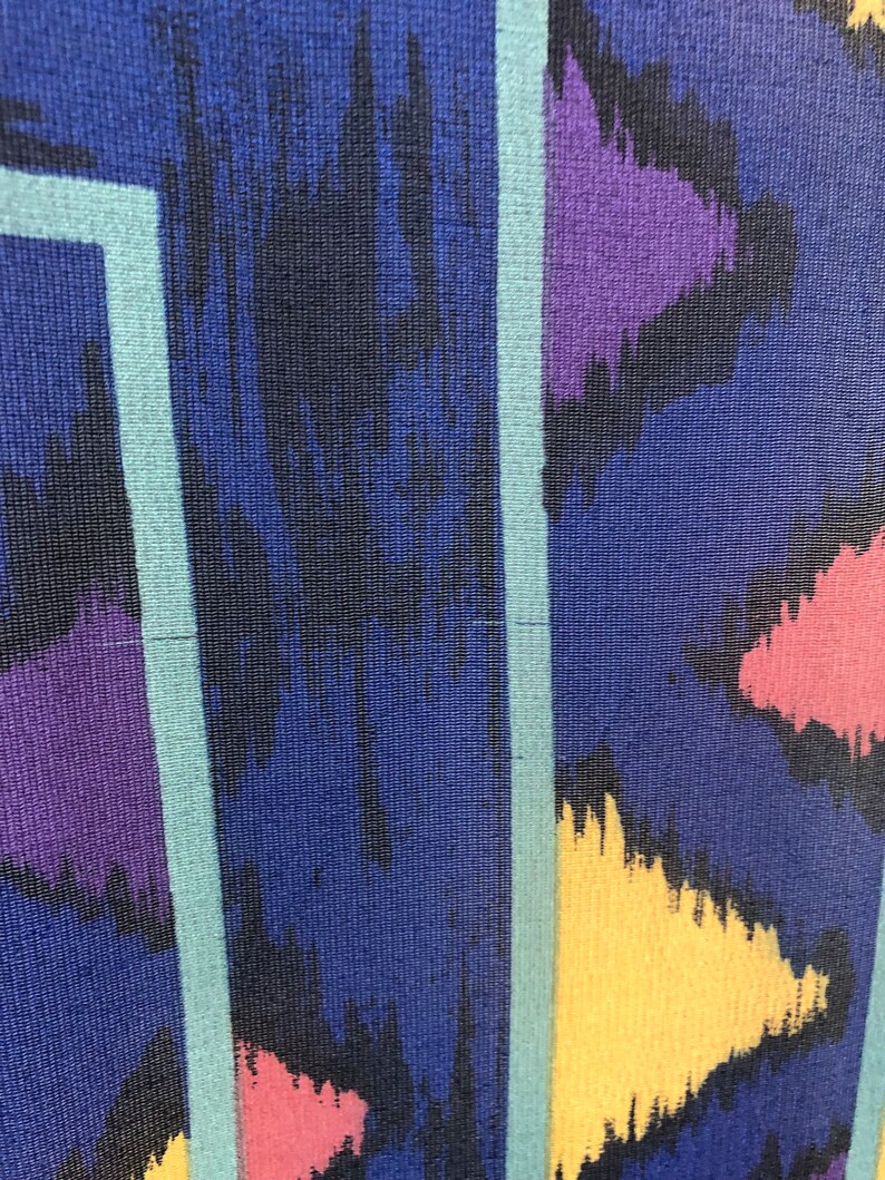 May include: Abstract pattern fabric with a blue background and colorful geometric shapes. The fabric has a textured surface and a striped pattern.