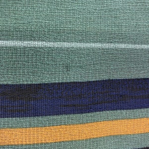 May include: A close-up of a woven fabric with horizontal stripes in shades of green, blue, and yellow.