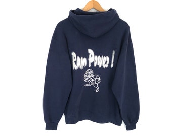 May include: Navy blue hooded sweatshirt featuring the text "Ram Power!" in white lettering on the back, with a white graphic of a ram playing football. The hoodie has a hood and long sleeves.