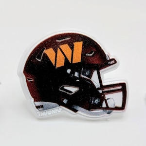 May include: A brown and orange football helmet with a white background. The helmet has a white face mask and a white "W" on the side.