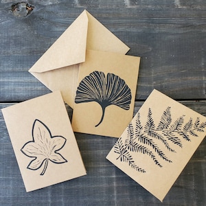 Biglietti di auguri con foglie di felce, ginkgo e edera stampati a mano su linoleum con stampa a blocchi.