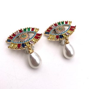 Clip-on earrings with multi-colored rhinestone eyes and dangling pearls.