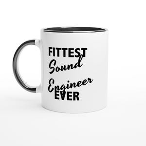 Puede incluir: Taza de cerámica blanca con borde y asa negros. La taza presenta el texto "FITTEST Sound Engineer EVER" en negro, en negrita y en cursiva. La taza está diseñada para ingenieros de sonido.