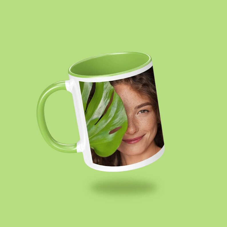 A green mug with a photo of a smiling woman printed on it, set against a green background.