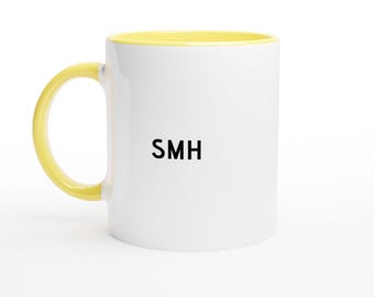 May include: White ceramic mug with a yellow interior and handle. The mug features the black letters "SMH" on the front. The mug is set against a white background.