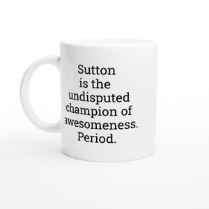May include: White ceramic mug with a curved handle. The mug features the text "Sutton is the undisputed champion of awesomeness. Period." in black, centered on the front. The mug is set against a white background.