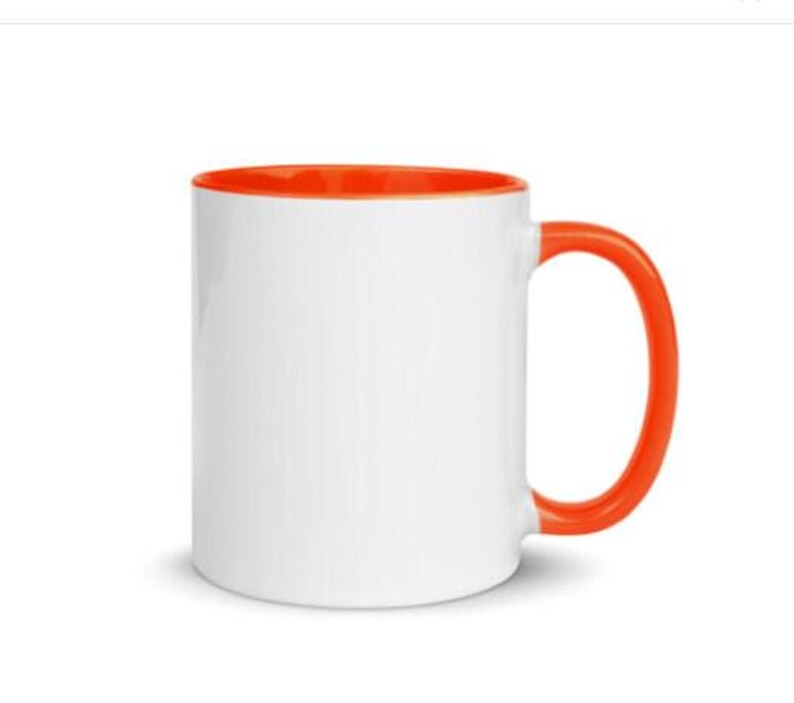 A white ceramic mug with an orange interior and handle.