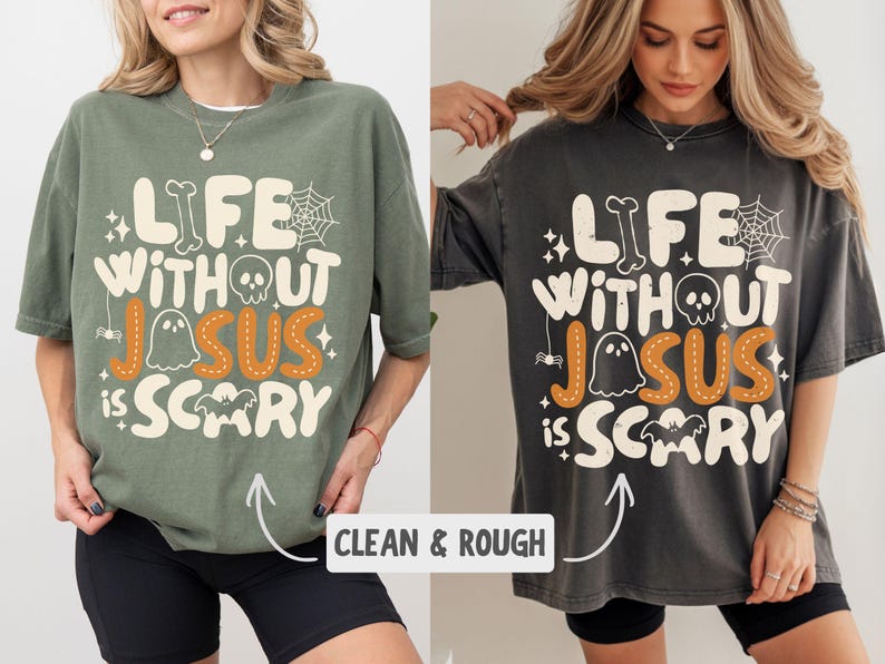 May include: An olive green and a charcoal grey t-shirt, each featuring the cream-colored text "LIFE WITHOUT JESUS IS SCARY" with orange stitching details on the word "JESUS". The design includes a skull, spiderweb, ghost, and bat graphic.