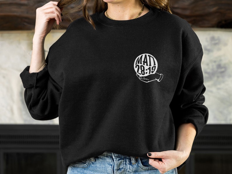 May include: Black sweatshirt with a white graphic of a hand holding a sphere with the text "MATT 28:19" inside.