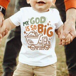 May include: A white toddler t-shirt with a brown truck graphic and the text "My God is so Big" with a scripture reference "PS. 147.5".