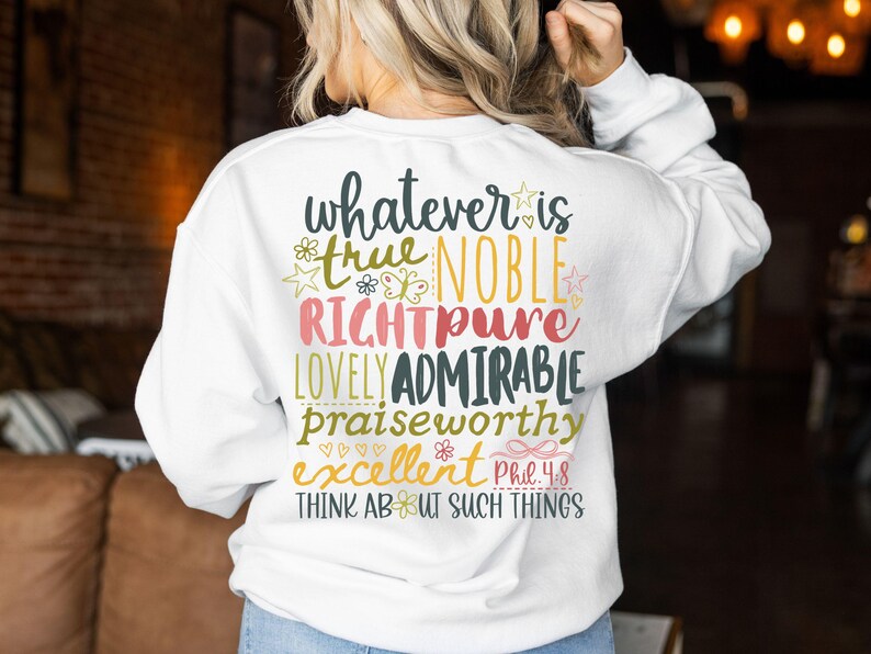 May include: White sweatshirt with colorful text on the back. The text includes words like "true," "noble," "lovely," and "admirable," along with the phrase "Think About Such Things." The design features floral and star accents.