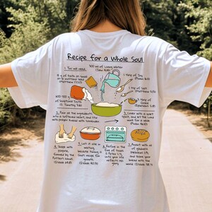 May include: White t-shirt with a graphic of a recipe for a whole soul. The recipe includes ingredients like faith, scriptural truth, and grace. The text is in black, with illustrations of the ingredients and steps.
