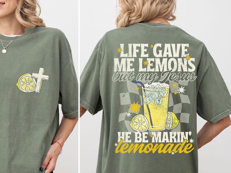 May include: Olive green t-shirt with a cross and lemon graphic on the front. The back features the text "LIFE GAVE ME LEMONS but my Jesus HE BE MAKIN' lemonade" with a lemonade graphic.