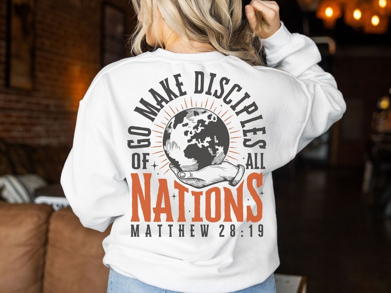 May include: White sweatshirt with a graphic print of a hand holding a globe with the text "Go Make Disciples of All Nations Matthew 28:19".