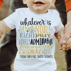 May include: White short-sleeved t-shirt with the text "whatever is true, noble, right, pure, lovely, admirable, praiseworthy, excellent" in various colors. The shirt also includes the text "Phil 4:8" and "Think about such things".