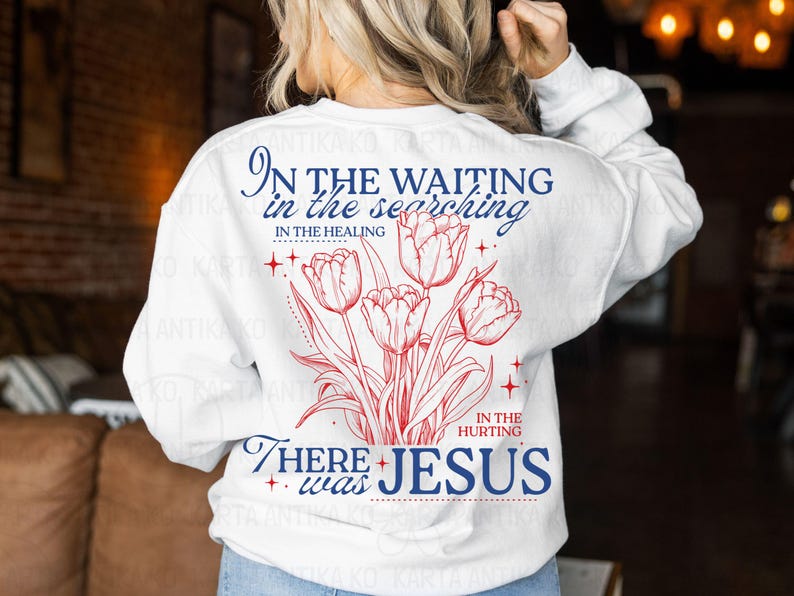 May include: White sweatshirt with a red and blue floral design and text. The text reads "In the waiting, in the searching, in the healing, in the hurting, there was Jesus."