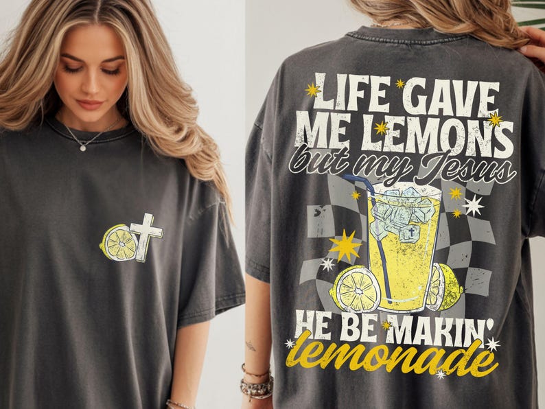 May include: Dark gray t-shirt with a lemon and cross graphic on the front. The back of the shirt features a lemonade graphic with the text "LIFE GAVE ME LEMONS but my Jesus HE BE MAKIN' lemonade."