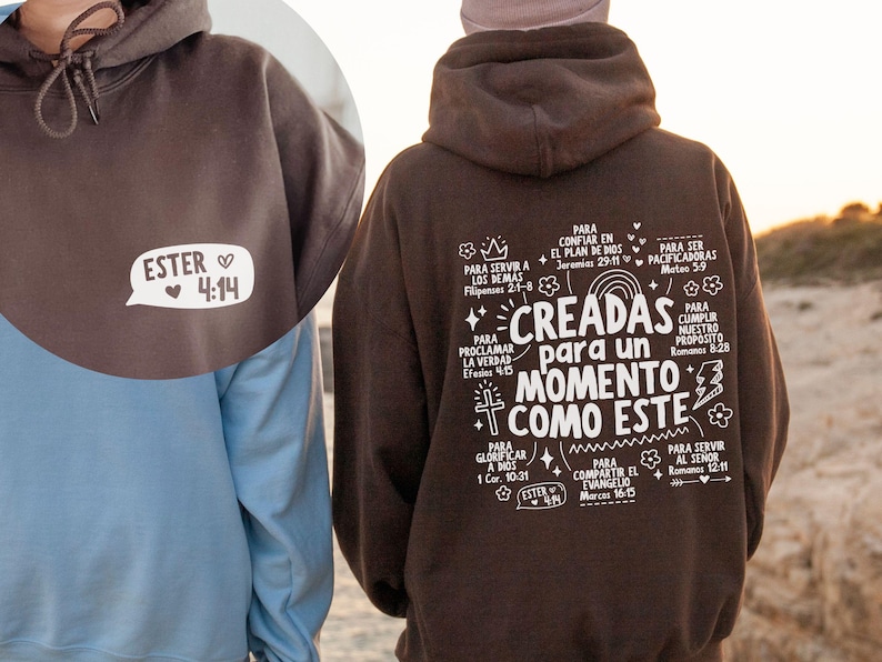 May include: A brown hoodie with the text "ESTER 4:14" in a white speech bubble on the front. The back of the hoodie features a white graphic with Spanish text and illustrations. The hoodie is made of a soft material.