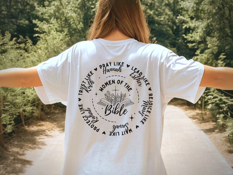 May include: White t-shirt with a black circle design featuring the text "Women of the Bible" and a Bible with flowers. The circle also includes phrases like "Trust like Ruth", "Pray like Hannah", "Lead like Esther", "Rejoice like Mary", "Protect like Sarah", and "Wait like  Song of Songs".