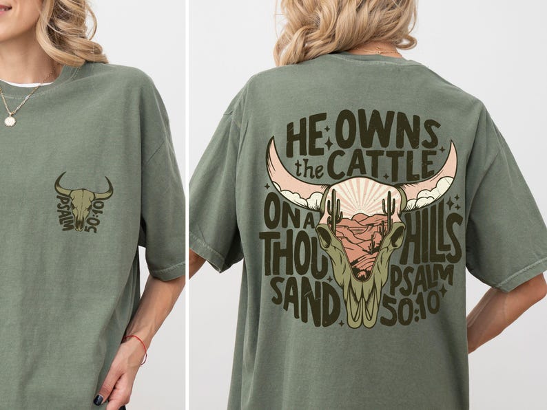 May include: Olive green t-shirt with a bull skull graphic. The front features a small bull skull design with the text "PSALM 50:10". The back displays a larger bull skull with the text "HE OWNS THE CATTLE ON A THOUSAND HILLS PSALM 50:10".