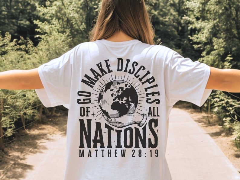 May include: White t-shirt with a black graphic design featuring a globe, hands, and the text "Go Make Disciples of All Nations Matthew 28:19".
