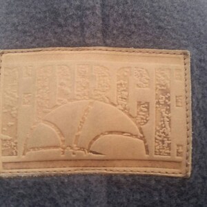 May include: A brown leather patch with the word "HURLEY" embossed in a stylized font. The patch has a stitched border and a design of a basketball inside a circle.